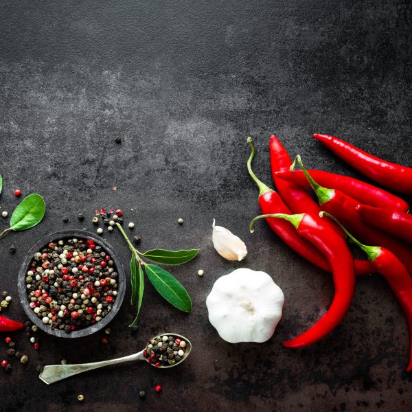 Red,Hot,Chili,Pepeprs,And,Peppercorns,On,Black,Metal,Background,
